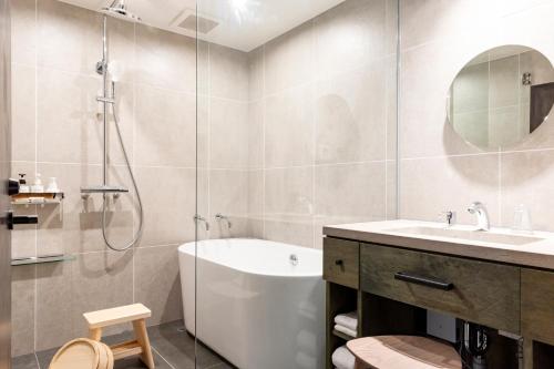 a bathroom with a shower and a tub and a sink at Hotel mio in Shimabara