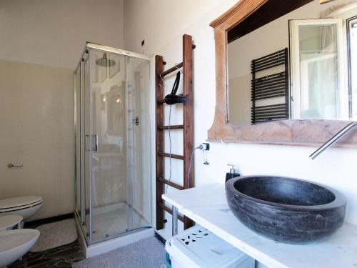 y baño con lavabo y ducha acristalada. en Rustic Holiday Home in Montemarzino with Garden, en Casasco