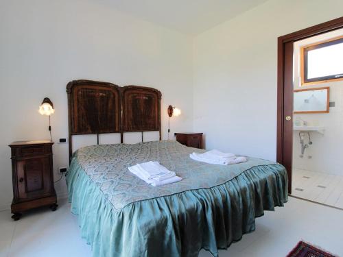 a bedroom with a bed with two towels on it at Rustic Holiday Home in Montemarzino with Garden in Casasco