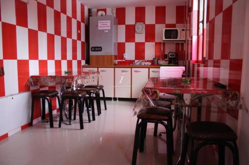 - une cuisine avec des murs à rayures rouges et blanches, des tables et des chaises dans l'établissement Casa Marian, à Buşteni