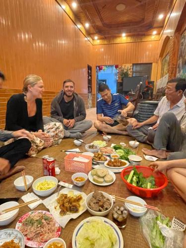 a group of people sitting around a table with food at Vani's Home in Ninh Binh