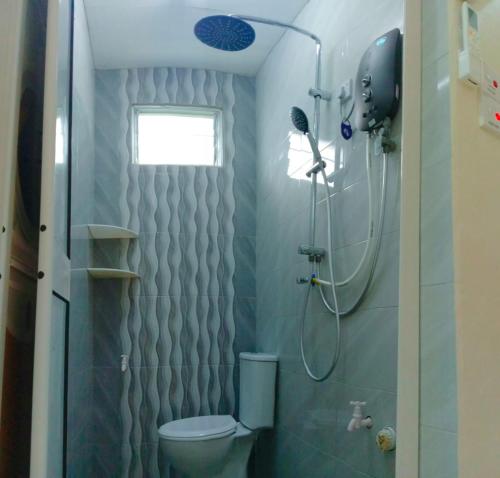 y baño con ducha y aseo. en CMS HOMESTAY ALOR SETAR en Alor Setar
