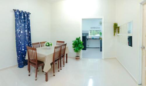 a dining room with a table and chairs and a kitchen at CMS HOMESTAY ALOR SETAR in Alor Setar