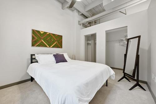 a white bedroom with a large white bed in it at Industrial Loft Apartments in the Beautiful Superior Building Minutes from FirstEnergy Stadium 311 in Cleveland