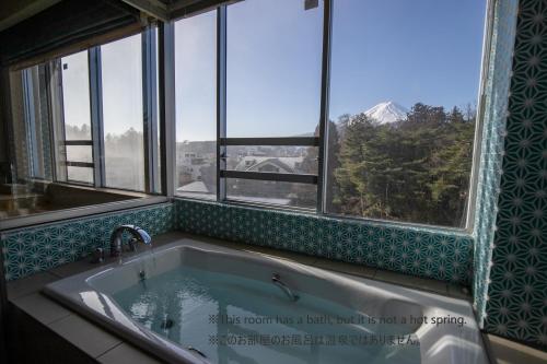 a bath tub with a view of a mountain at Fuji Lake Hotel in Fujikawaguchiko
