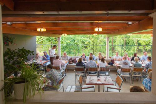 a group of people sitting at tables on a patio at Rooms Villa Amfora Dubrovnik in Dubrovnik