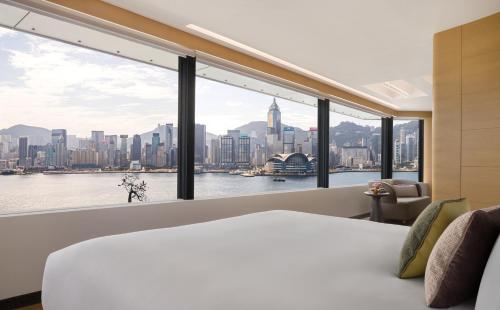 a bedroom with a large window with a city view at Regent Hong Kong in Hong Kong