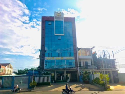 two people riding motorcycles in front of a building at Hotel Mỹ Mỹ in Tây Ninh