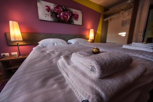 a bedroom with a bed with towels on it at OH Apartments & Rooms in Ljubljana