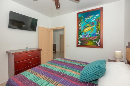 1 dormitorio con 1 cama y una pintura en la pared en Alpha's Place - Unit 3C, en Sandy Bay