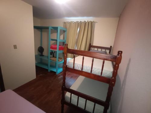 a bedroom with two bunk beds and a blue shelf at Casa da Frente Santa Felicidade in Curitiba