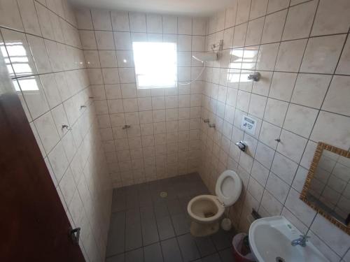 a bathroom with a toilet and a sink at Casa da Frente Santa Felicidade in Curitiba