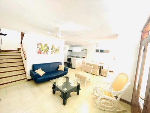 sala de estar con sofá azul y mesa en Uchuva beach house, en Santa Marta