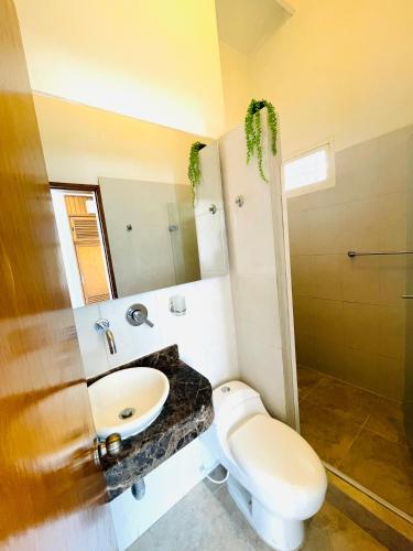 a bathroom with a toilet and a sink at Casa de playa en Bello Horizonte a una cuadra del mar in Santa Marta