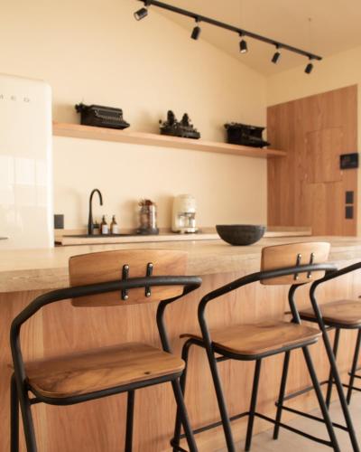 a kitchen with two bar stools at a counter at Casa Nova Centro Oaxaca - Adults Only in Oaxaca City