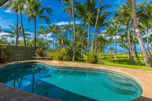 una piscina con palmeras en el fondo en Halama Hale Private Home home, en Kihei