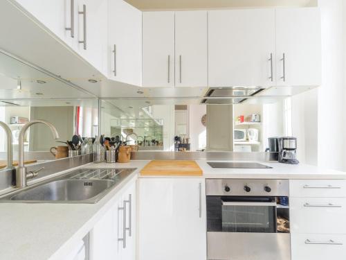 une cuisine avec des armoires blanches et des appareils en acier inoxydable dans l'établissement Charmant 2 pièces tout confort à 20m du Vieux Port, idéal pour 2 personnes - FR-1-535-44, à La Rochelle