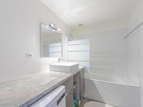 ein weißes Badezimmer mit einem Waschbecken und einer Badewanne in der Unterkunft Appartement La Rochelle, 2 pièces, 2 personnes - FR-1-535-44 in La Rochelle