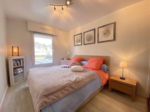 ein Schlafzimmer mit einem Bett mit orangefarbenen Kissen und einem Fenster in der Unterkunft Appartement Pornichet, 2 pièces, 4 personnes - FR-1-245-180 in Pornichet