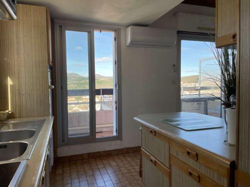 a kitchen with a large window with a view at Appartement T3 Mezzanine 6 Couchages à 300m de la plage, Parking Privé - FR-1-225C-118 in Banyuls-sur-Mer