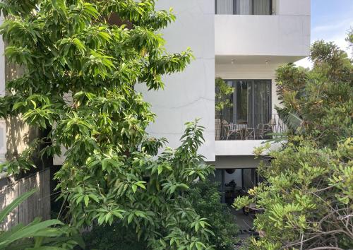 a white house with trees in front of it at Green River Boutique Hotel in Vung Tau