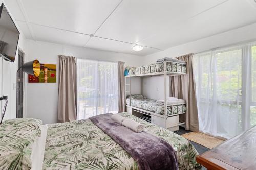 a bedroom with two bunk beds and a window at Riverside Accommodation in Karangahake