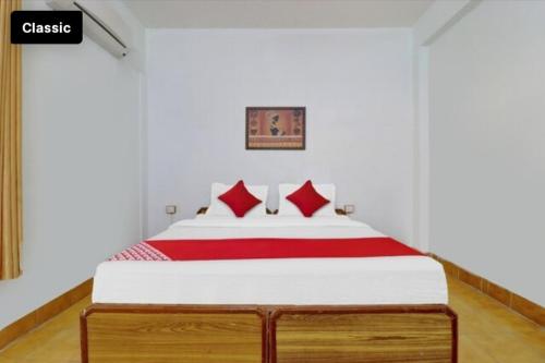 HOTEL GANGA VIEW harry stay في Shivpuri: غرفة نوم بسرير كبير ومخدات حمراء