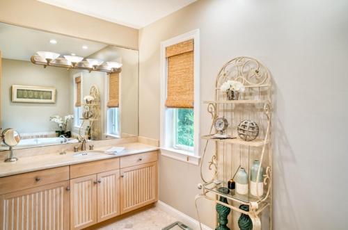 La salle de bains est pourvue d'un lavabo, d'un miroir et d'une étagère. dans l'établissement Captiva Grace home, à Captiva