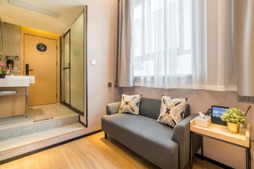 a living room with a couch and a mirror at Meego Smart Select Hotel in Shanghai