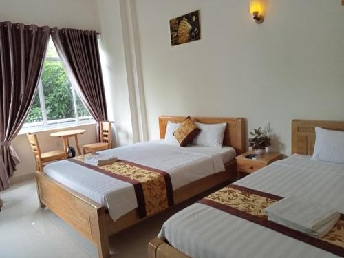 a bedroom with two beds and a window at Khách sạn Trọng Tín in Con Dao