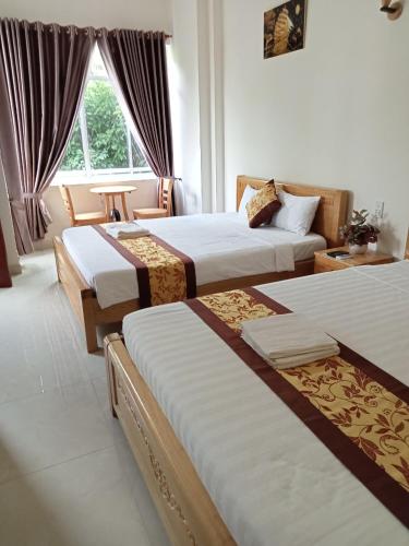 a hotel room with three beds and a window at Khách sạn Trọng Tín in Con Dao