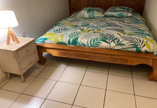 una camera da letto con un letto e una lampada su un pavimento piastrellato di Chalet DIKA a Cilaos