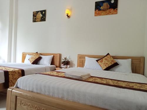 two beds sitting next to each other in a room at Khách sạn Trọng Tín in Con Dao