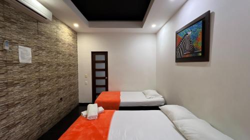 two beds in a room with a wall at Hotel Family House Rodadero in Santa Marta
