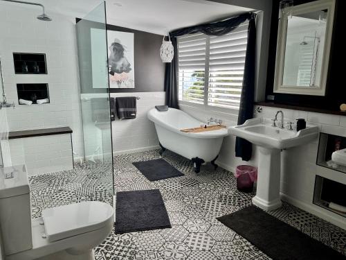 La salle de bains est pourvue d'une baignoire, de toilettes et d'un lavabo. dans l'établissement Mahalo BnB, à Mapleton