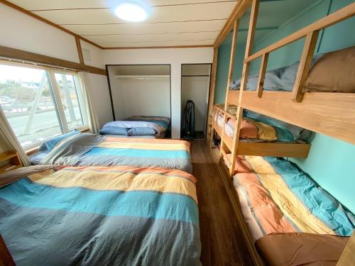 two bunk beds in a small room with a window at Port Front ポートフロント 釣りに最適 in Shikyū