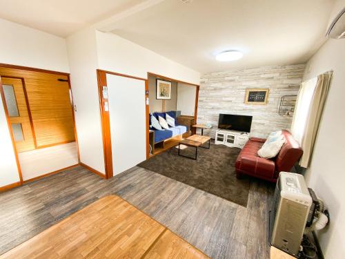 a living room with a couch and a tv at Port Front ポートフロント in Shiraoi