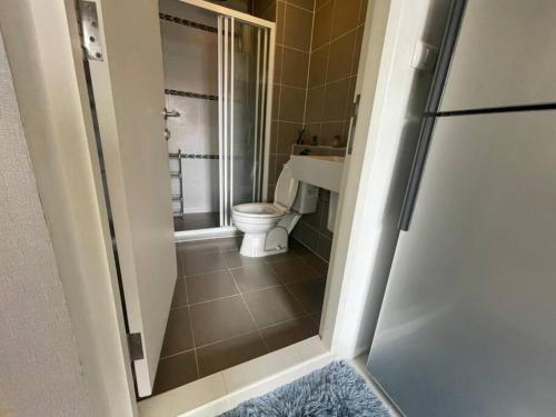 a bathroom with a toilet and a glass shower door at D condo sign A72 in Chiang Mai