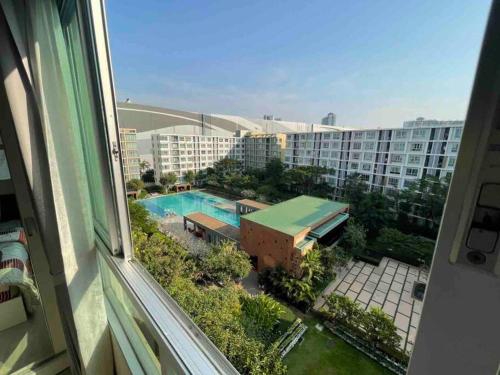 - une vue sur la piscine depuis la fenêtre d'un bâtiment dans l'établissement D condo sign A72, à Chiang Mai