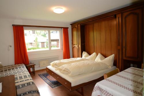 Schlafzimmer mit einem Bett und einem Fenster in der Unterkunft Haus Richemont in Zermatt