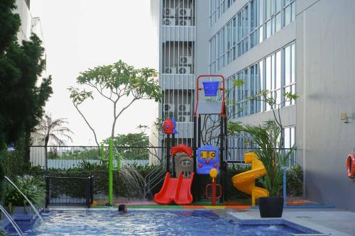 um parque infantil num edifício com piscina em The Premiere Hotel Pekanbaru em Pekanbaru