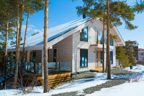 Une petite maison blanche avec des arbres dans la neige dans l'établissement Park Hotel Kokshetau, à Chtchoutchinsk