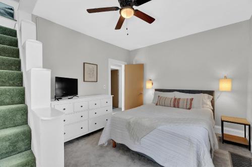 een witte slaapkamer met een bed en een plafondventilator bij Cozy Cottage in the Heart of Hyde Park home in Cincinnati