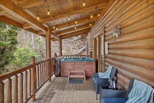 a deck with a hot tub and chairs on a cabin at 5 O'Clock Somewhere cabin in Sevierville