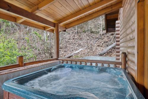 a jacuzzi tub in a wooden house at 5 O'Clock Somewhere cabin in Sevierville