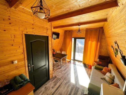 a wooden room with a door and a desk at Cabana A-Frame Refugiu Montan in Băişoara