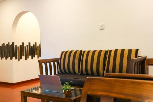 a living room with a couch and a laptop on a table at Bambara Ella Agro Resort & Camping in Haputale