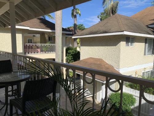 balkon ze stołem i krzesłami oraz budynek w obiekcie Family Comfort in Jamaica - Enjoy 7 miles of White Sand Beach! villa w Negril