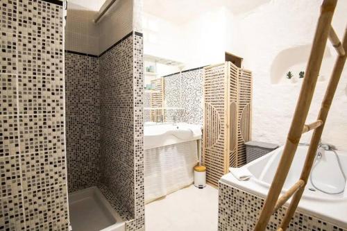 ein Badezimmer mit einer Badewanne, einem Waschbecken und einer Badewanne in der Unterkunft Maison troglodyte - Le Cerisier Perché in Luynes