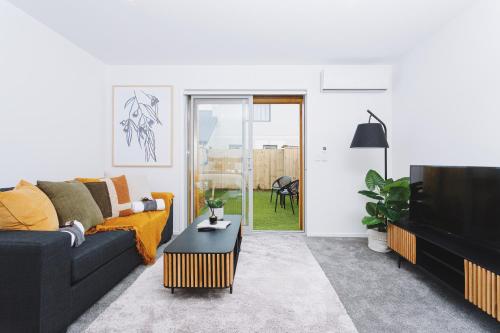 a living room with a couch and a table at 1 bed Central City Deluxe w/carpark in Christchurch